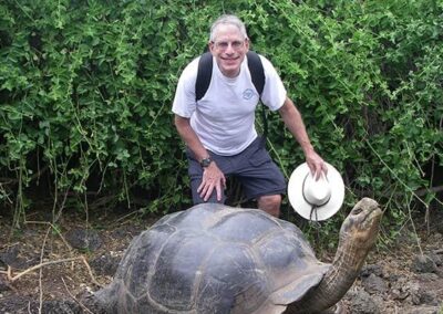Man and Galapagos tortoise smiling for the camera - Endless River Adventures